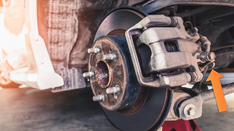 Rear brake caliper showing the parking brake engager (orange arrow). On modern cars, you need computer control to adjust it. stock.adobe.com